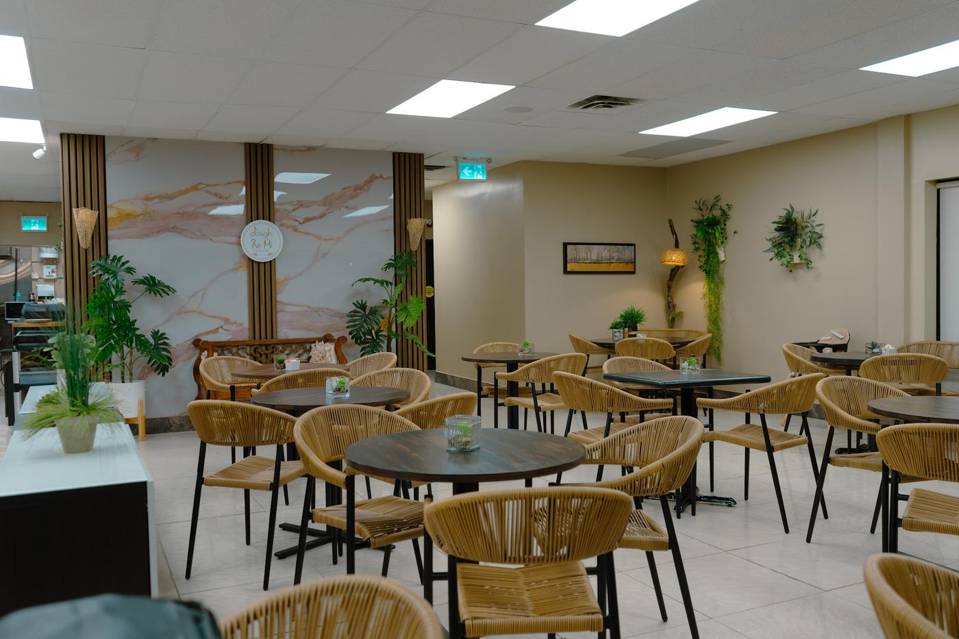 Dining room with rattan chairs, round tables and a marble feature wall